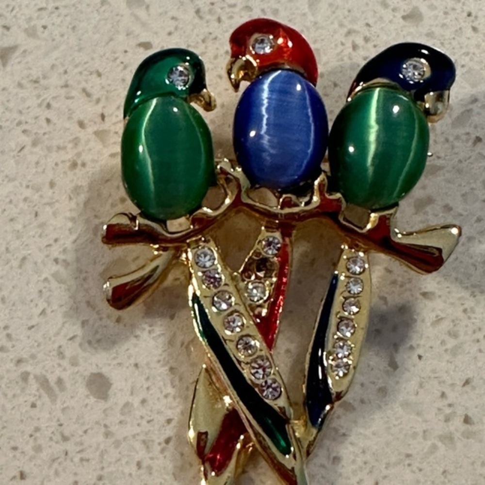 3 bird brooch in green and blue in gold tone. Pre owned has ones crystal missing
